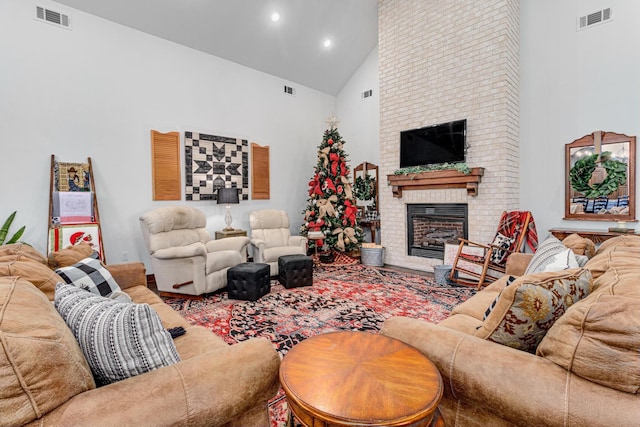 living room with high vaulted ceiling and a brick fireplace