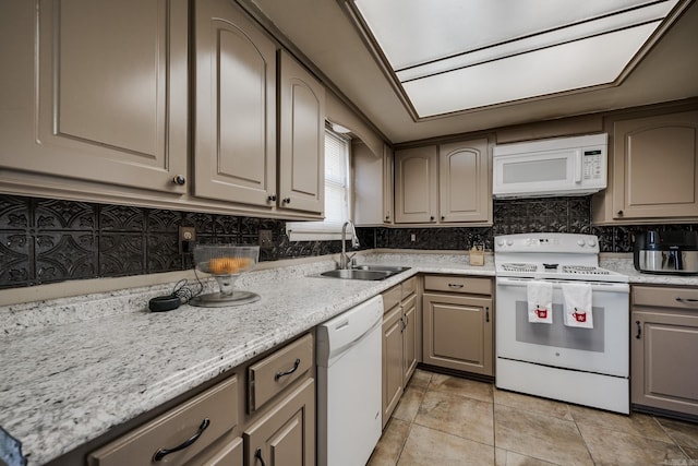 kitchen with sink, white appliances, light tile patterned floors, backsplash, and light stone countertops