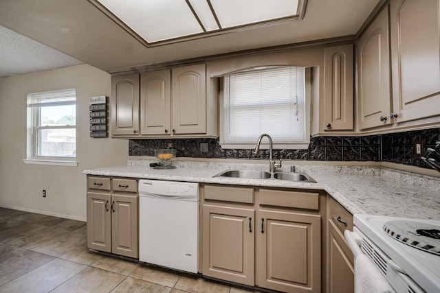 kitchen featuring tasteful backsplash, sink, light tile patterned floors, light stone countertops, and white appliances