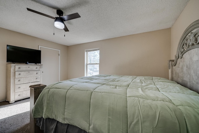 bedroom with ceiling fan, carpet floors, and a textured ceiling