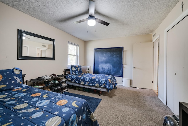 carpeted bedroom with ceiling fan and a textured ceiling