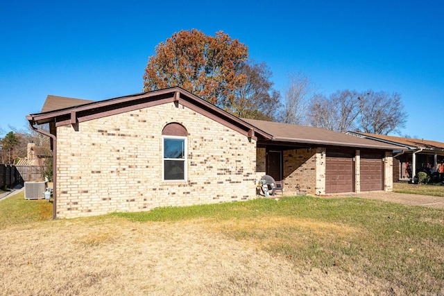 view of front of house with cooling unit, a garage, and a front yard