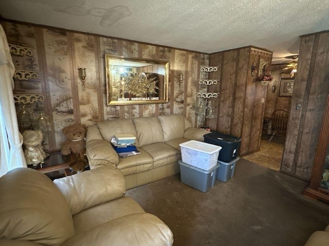 carpeted living room with ceiling fan, a textured ceiling, and wood walls