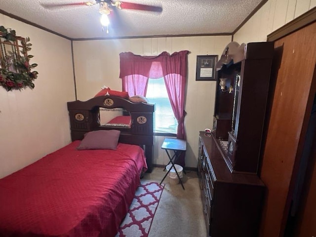 bedroom with crown molding, carpet flooring, ceiling fan, and a textured ceiling