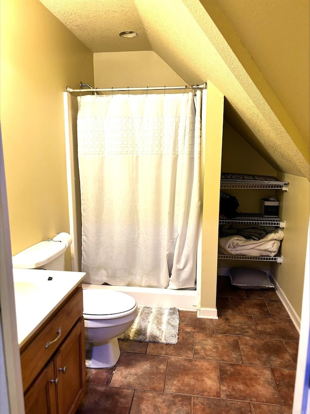 bathroom with lofted ceiling, toilet, a shower with curtain, a textured ceiling, and vanity