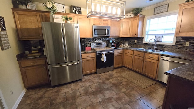 kitchen with sink, crown molding, decorative light fixtures, appliances with stainless steel finishes, and backsplash