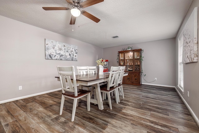 dining space with dark hardwood / wood-style flooring and a textured ceiling