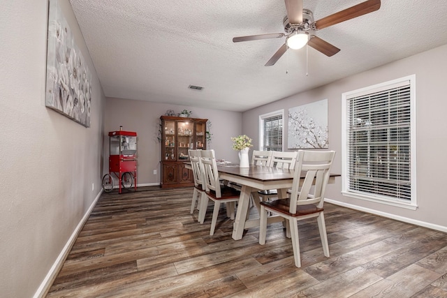 dining area with ceiling fan, dark hardwood / wood-style floors, and a textured ceiling