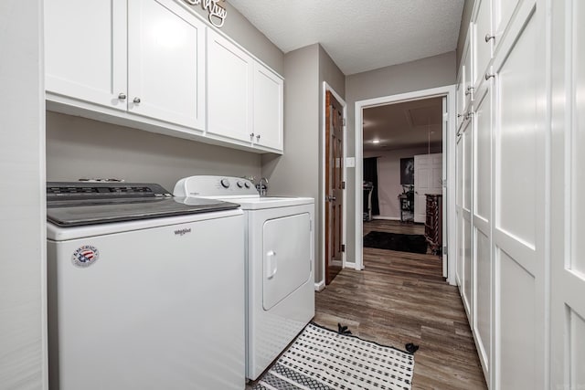 washroom with cabinets, washing machine and dryer, dark hardwood / wood-style floors, and a textured ceiling