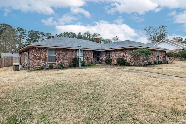 ranch-style house with a front yard and central AC unit