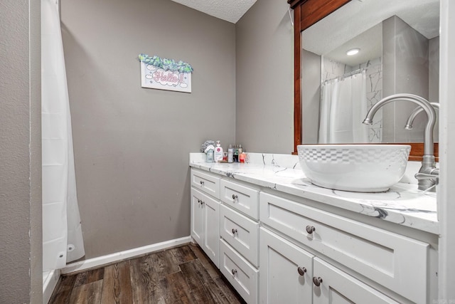 bathroom with hardwood / wood-style flooring, vanity, a shower with curtain, and a textured ceiling