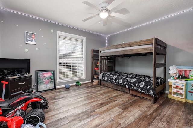 bedroom featuring ceiling fan, a textured ceiling, and light wood-type flooring