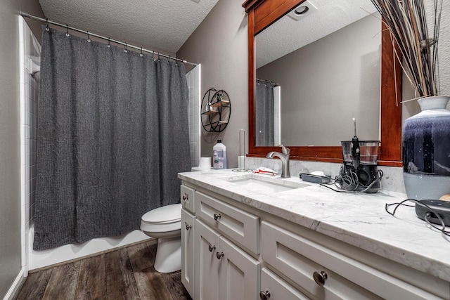 bathroom with vanity, wood-type flooring, toilet, and a textured ceiling