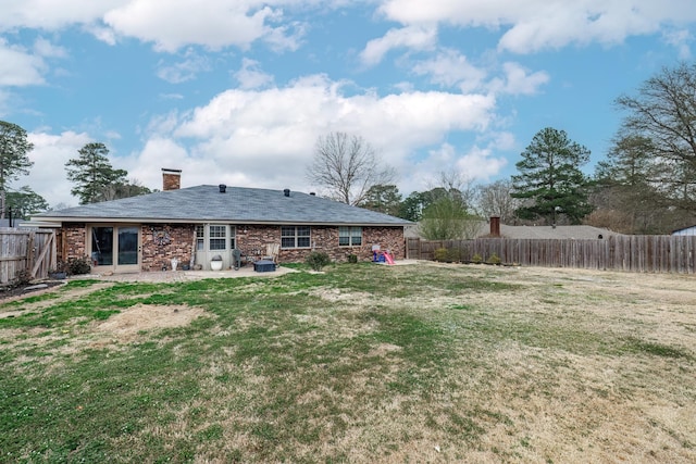 back of house with a patio area and a lawn