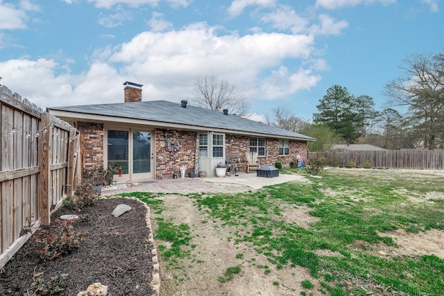 back of house featuring a patio and a lawn