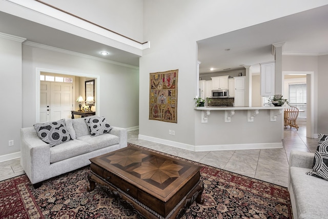 living room with a towering ceiling and ornamental molding