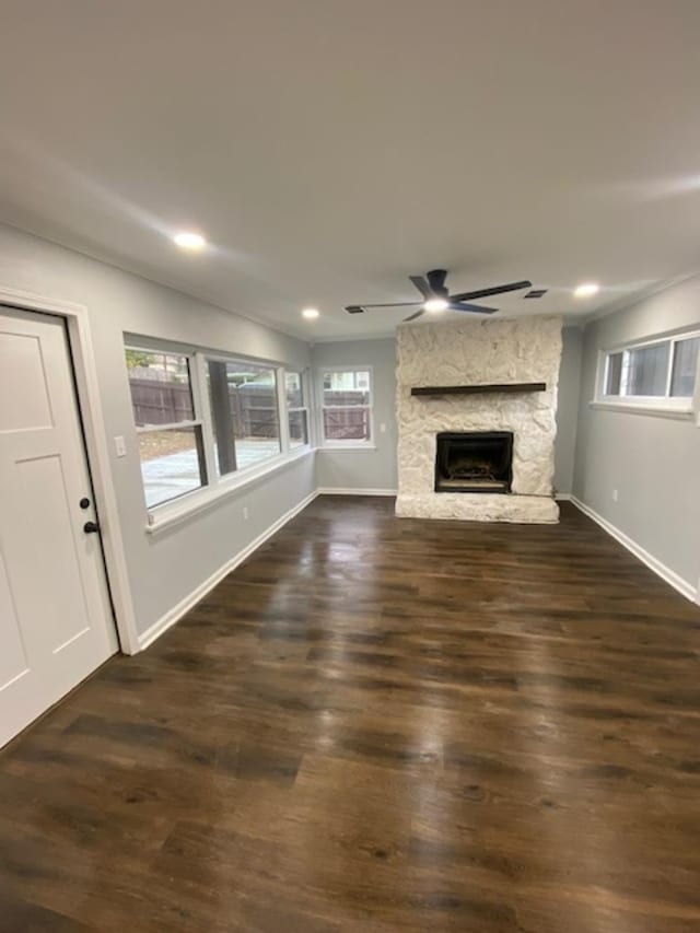 unfurnished living room featuring ceiling fan, a fireplace, and dark hardwood / wood-style flooring