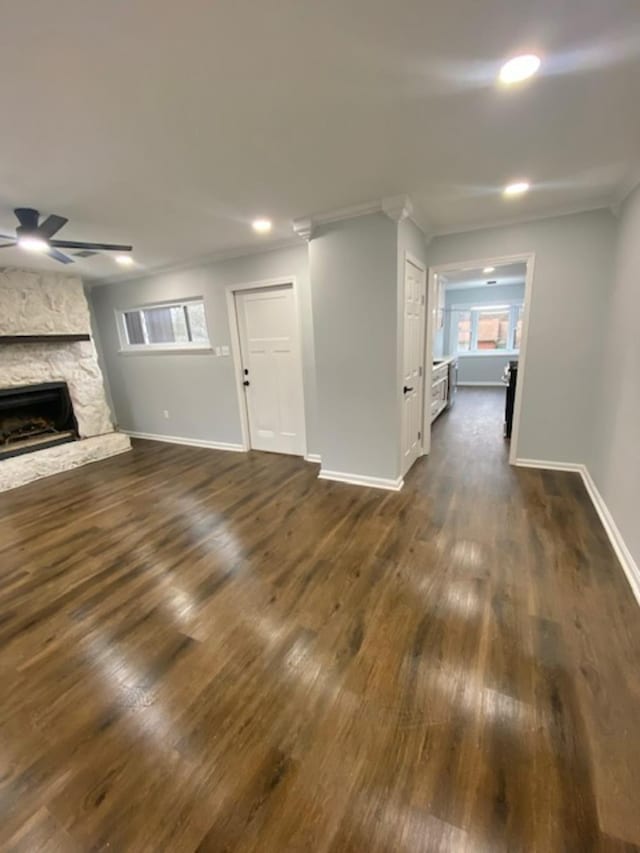 unfurnished living room with crown molding, dark hardwood / wood-style floors, a fireplace, and ceiling fan