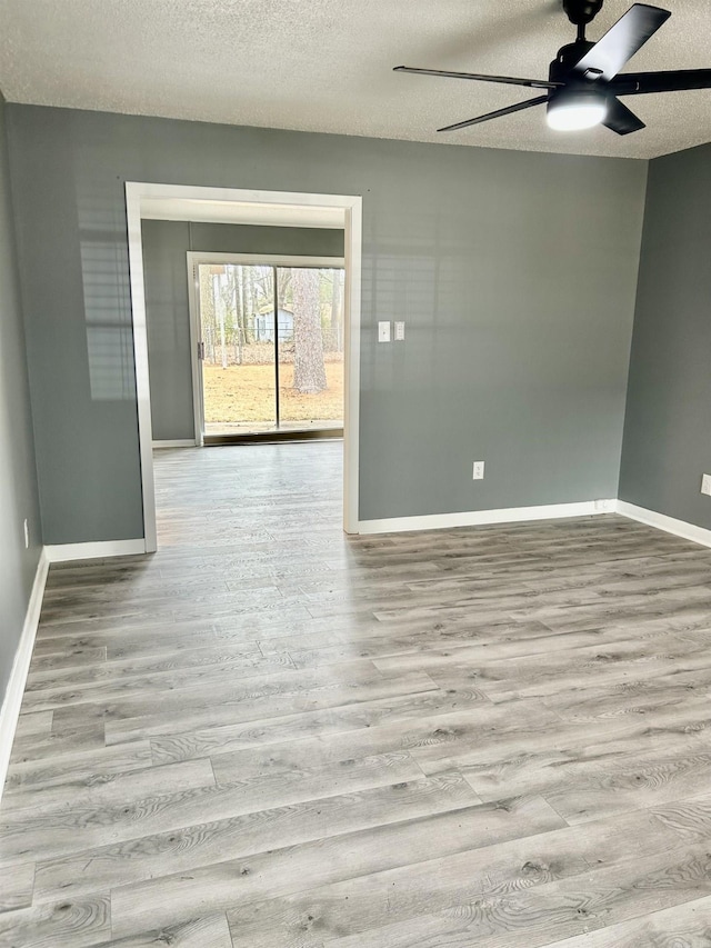 spare room with ceiling fan, a textured ceiling, and light hardwood / wood-style floors