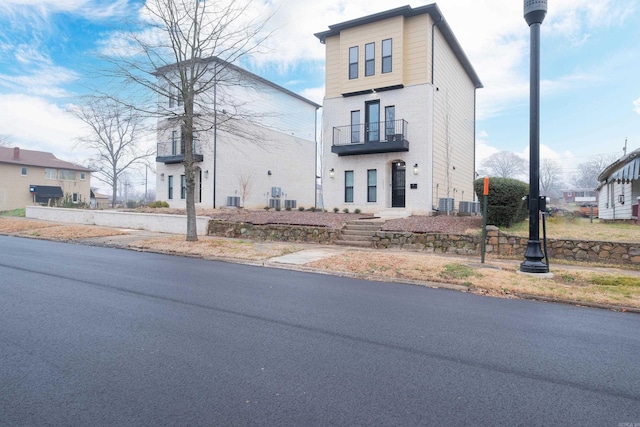 view of front of home featuring cooling unit and a balcony