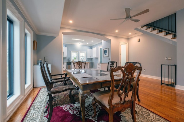 dining space featuring crown molding, light hardwood / wood-style floors, and ceiling fan