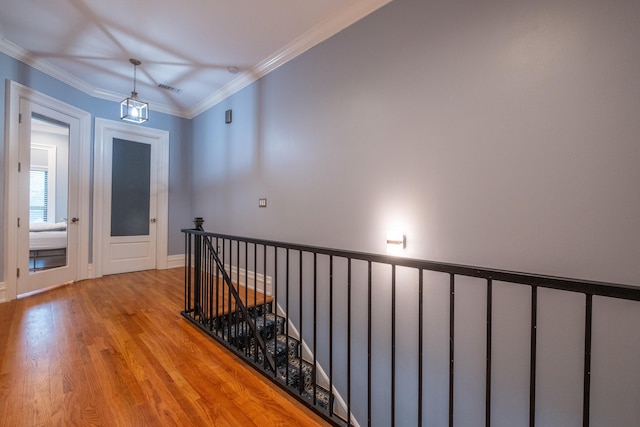 hall with ornamental molding and light hardwood / wood-style flooring