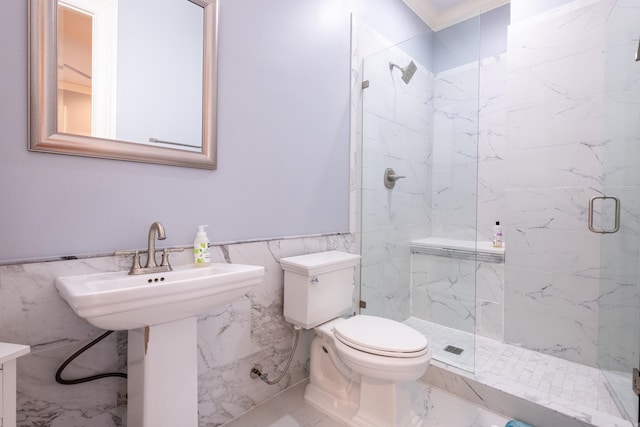 bathroom featuring toilet, a shower with door, and tile walls