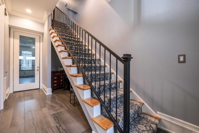 stairway with hardwood / wood-style flooring and crown molding