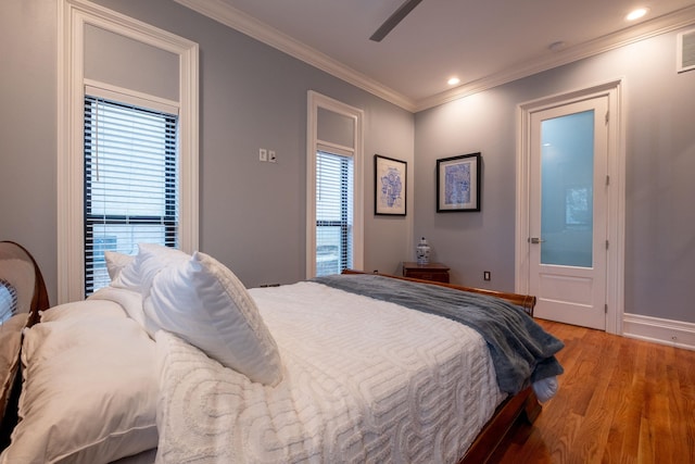 bedroom with wood-type flooring, ornamental molding, and ceiling fan