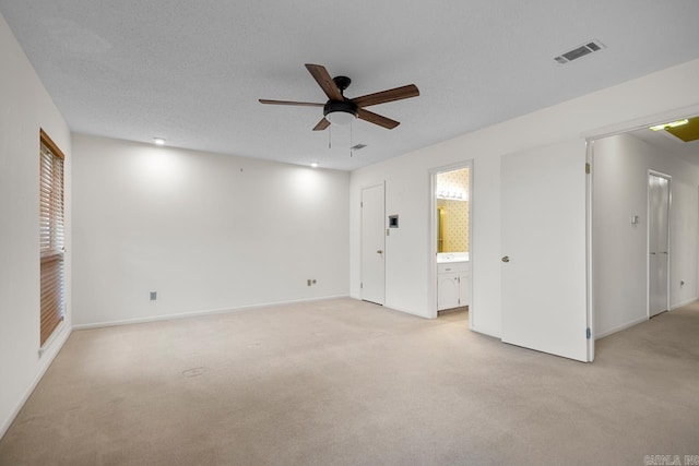 carpeted spare room with a healthy amount of sunlight, a textured ceiling, and ceiling fan