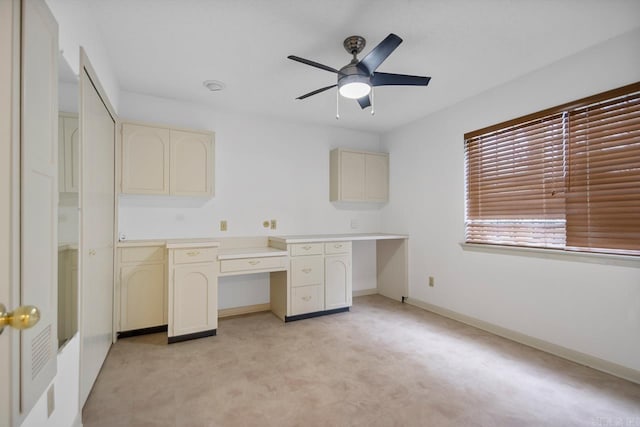 unfurnished office with ceiling fan and built in desk