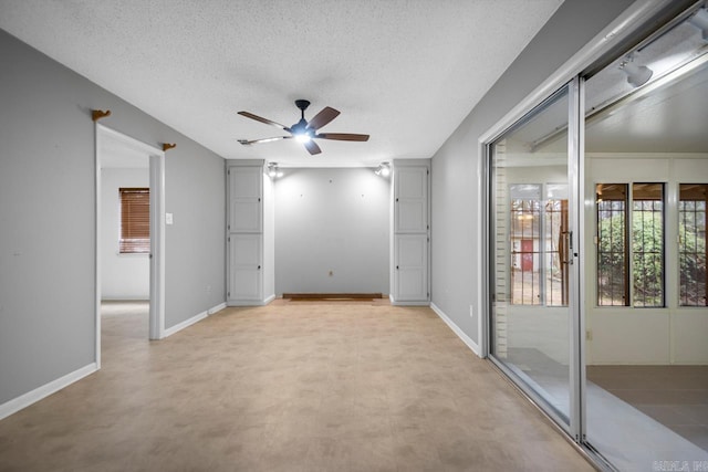 unfurnished room featuring ceiling fan and a textured ceiling