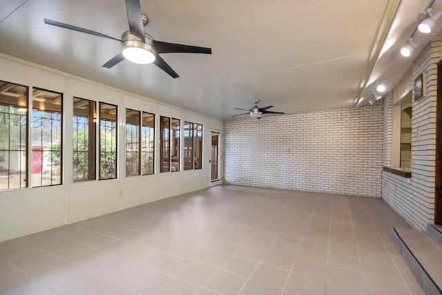 unfurnished sunroom featuring ceiling fan