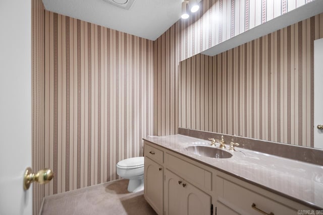 bathroom featuring vanity, a textured ceiling, and toilet