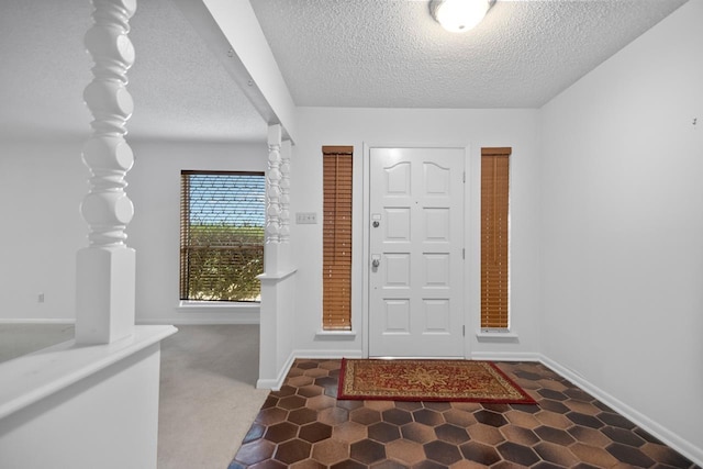 carpeted entrance foyer featuring a textured ceiling