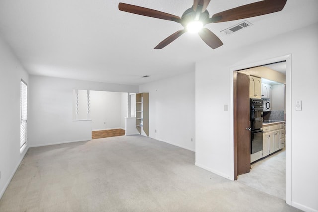 carpeted empty room featuring ceiling fan