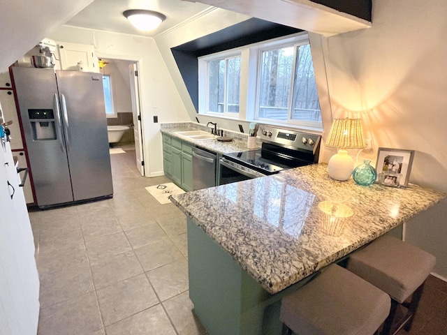 kitchen featuring green cabinetry, sink, light tile patterned floors, kitchen peninsula, and stainless steel appliances