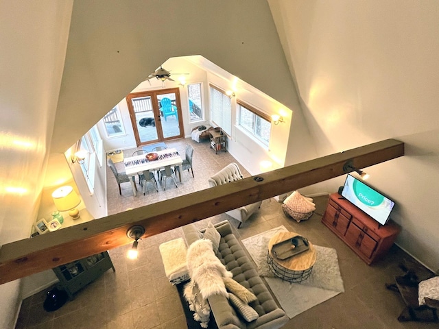 living room featuring a towering ceiling and ceiling fan