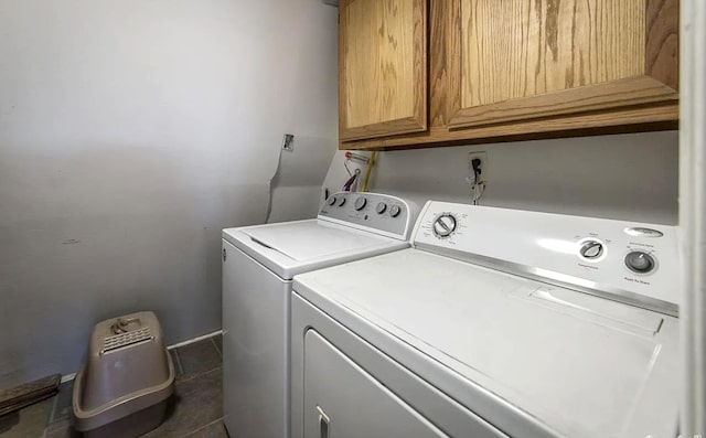 laundry area featuring independent washer and dryer, cabinets, and dark tile patterned floors