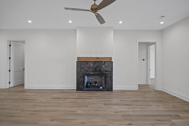 unfurnished living room with light wood-style flooring, a fireplace, and recessed lighting