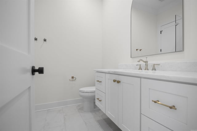 bathroom with marble finish floor, toilet, vanity, and baseboards