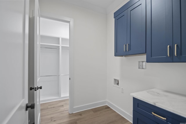 laundry area with cabinet space, hookup for a washing machine, baseboards, and light wood finished floors