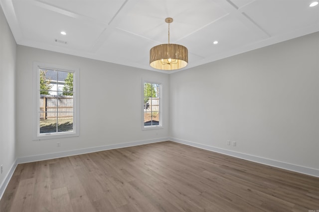 unfurnished room featuring a healthy amount of sunlight, coffered ceiling, and baseboards