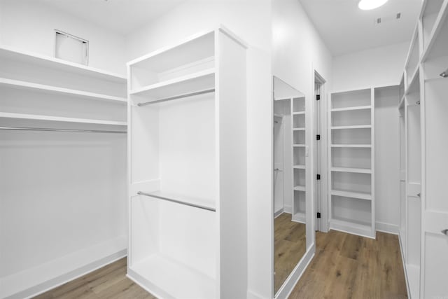 walk in closet featuring wood finished floors and visible vents