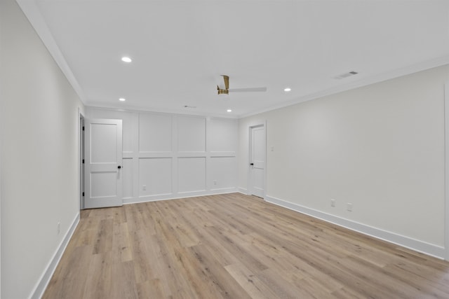 spare room with recessed lighting, a decorative wall, visible vents, light wood finished floors, and crown molding