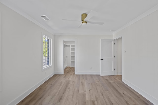 empty room with light wood finished floors, baseboards, visible vents, a ceiling fan, and ornamental molding