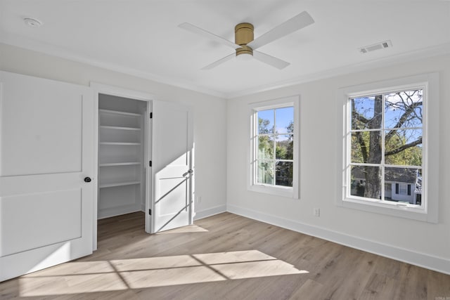 unfurnished bedroom with baseboards, multiple windows, visible vents, and light wood finished floors