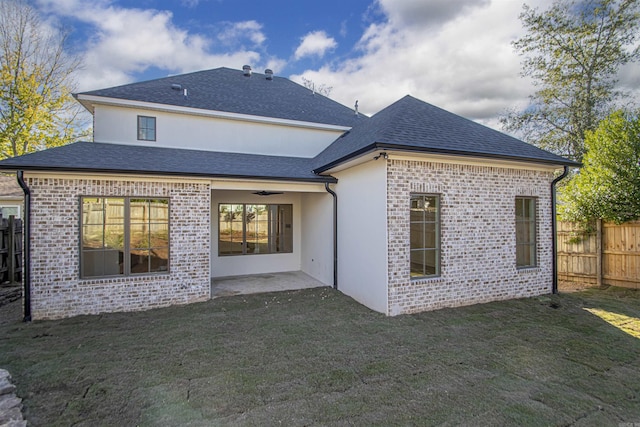 rear view of house featuring a lawn, fence, a patio, and brick siding