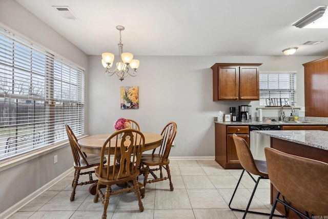 dining space featuring a notable chandelier, sink, and light tile patterned flooring