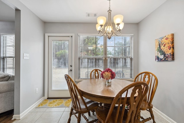 dining space featuring tile patterned flooring and a notable chandelier